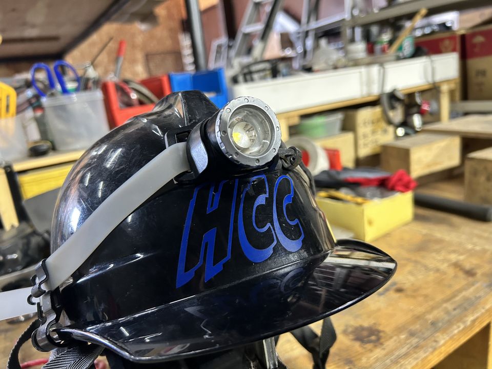 HCCのロゴ入りヘルメットと舞台修繕の作業場